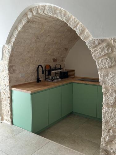 eine Küche mit einem Torbogen in einer Steinmauer in der Unterkunft Al Murigini - Casa Vacanze in Ceglie Messapica