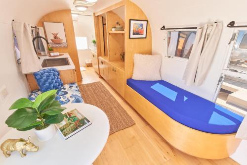a small room with a blue couch and a table at Acres Landing in Desert Hot Springs