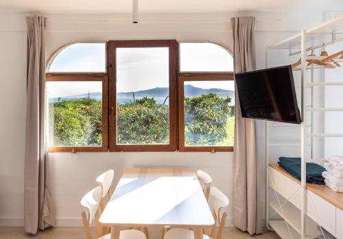 a room with a table and two windows at LUR Apartments Getaria in Getaria