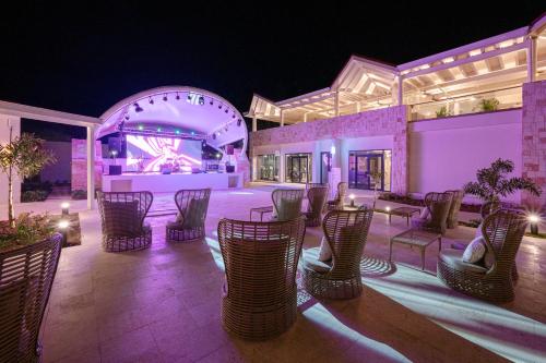 a group of chairs and tables on a patio at night at Royalton CHIC Antigua, An Autograph Collection All-Inclusive Resort - Adults Only in Saint Johnʼs