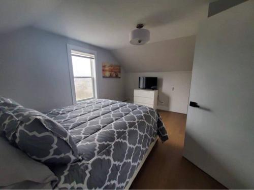 a bedroom with a bed and a window at The Cabot Suite in Chéticamp