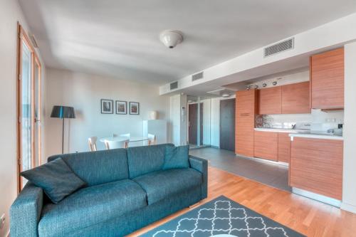 un salon avec un canapé bleu et une cuisine dans l'établissement GuestReady - Bel Appartement Croix-Rousse, à Lyon