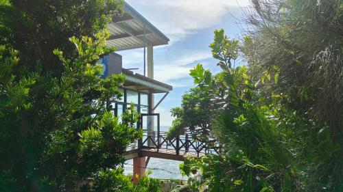 a tree house with a balcony in the middle of trees at Come and go seaside B&B in Fengbin