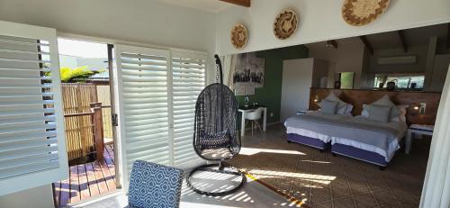 a bedroom with a bed and a chair in it at Elephant Hide of Knysna Guest Lodge in Knysna