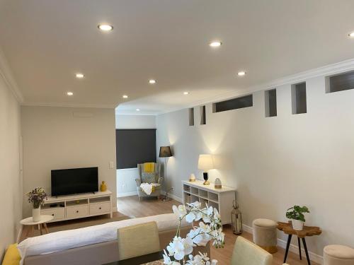 a living room with a flat screen tv on a wall at Casa Pátio country house in Enxara do Bispo