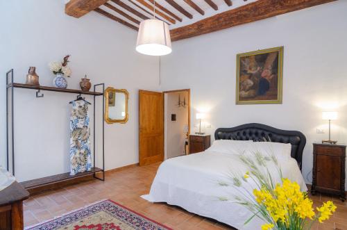a bedroom with a bed and a vase of flowers at Holiday Home Adelaide in Pienza