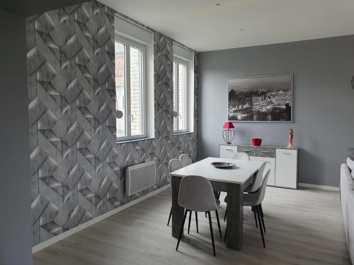 une salle à manger blanche avec une table et des chaises dans l'établissement maison tout confort, à Seboncourt