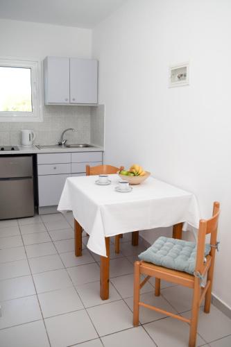 a kitchen with a table with a bowl of fruit on it at Marianthi Apts Anissaras in Hersonissos