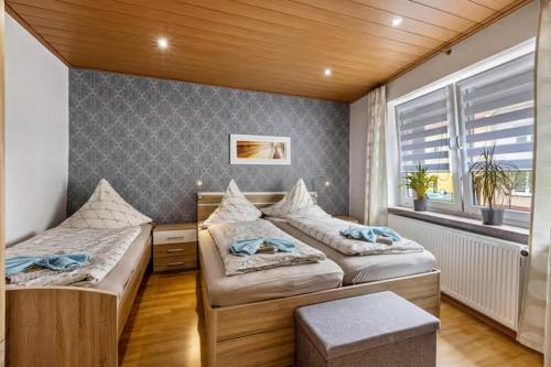 a bedroom with two beds and a window at Christels Ferienwohnung 2 in Thale mit überdachter Terrasse, Küche mit TV & Geschirrspüler in Thale