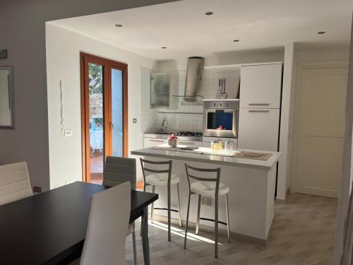 a kitchen with a kitchen island with chairs and a table at Da Masciu in La Maddalena