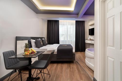 a room with a bed and a dining table and a bathroom at Bakırk&ouml;y Zeugma Suit Otel in Istanbul