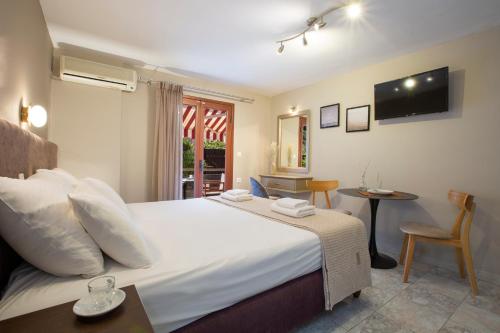 a bedroom with a large white bed and a table at Athina résidence in Nydri