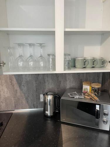 a kitchen counter with a microwave on a counter top at Birks road in Cleator Moor