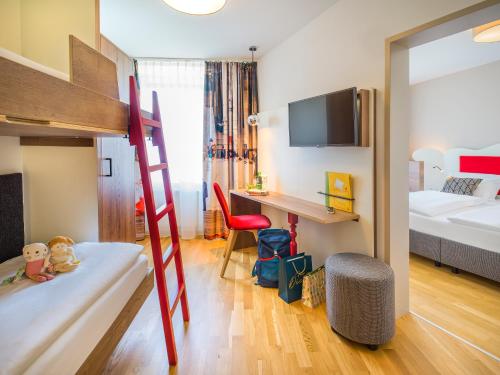 a small room with a bunk bed and a desk at JUFA Hotel Salzburg in Salzburg