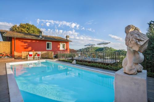 uma piscina com uma estátua ao lado de uma casa em The Sunset Hill with Private Swimming pool and A/C em Camaiore