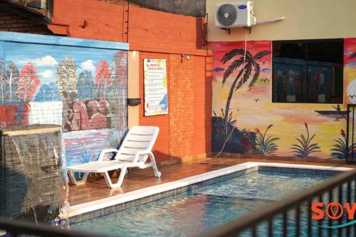 a chair sitting next to a swimming pool with a mural at Sublime y moderno alojamiento in Barrio San Isidro (2)