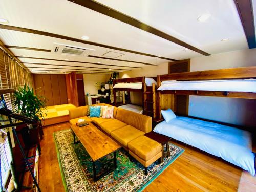 salon z kanapą i łóżkiem w obiekcie villa garden DaiDai w mieście Hiroszima