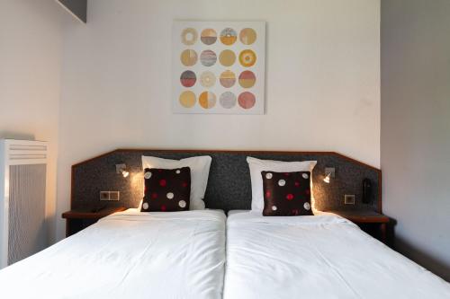 a bedroom with two beds with white sheets and pillows at Hôtel Restaurant La Vallée Noble, proche Eguisheim Colmar in Soultzmatt