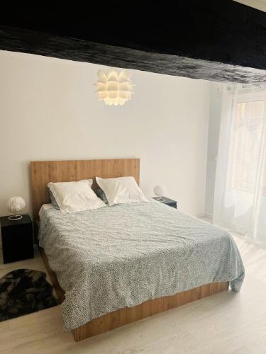 une chambre avec un grand lit avec une tête de lit en bois dans l'établissement Europe, à Épernay