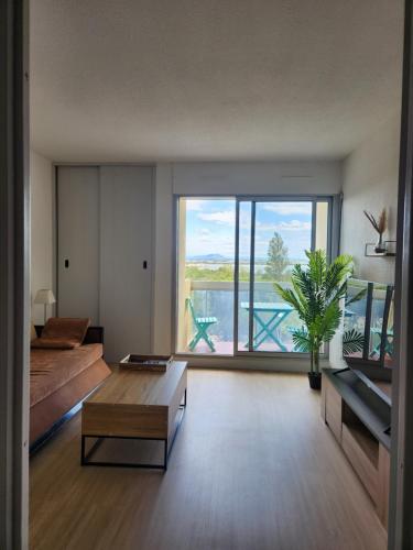 - un salon avec une grande fenêtre donnant sur l'eau dans l'établissement Le Sunset accès direct Port et à 5 min de la plage Carnon, à Mauguio