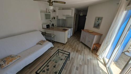 un petit salon avec un canapé et une cuisine dans l'établissement Jolie et Coquet Appartement T2 - Caicos 45, à Canet