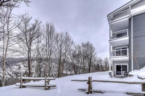 a building with a bench in the snow at Studio 104 Mont -Tremblant in Mont-Tremblant