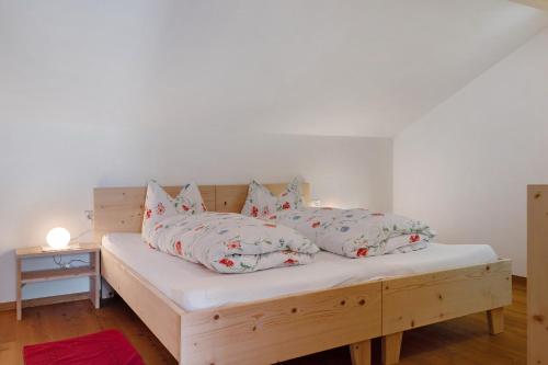 a bed with four pillows on it in a room at Waldchalet Ödenhof in Ponte Nova