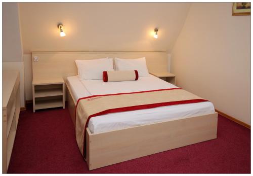 a bedroom with a large bed with a red carpet at Colibri Hotel in Novosibirsk