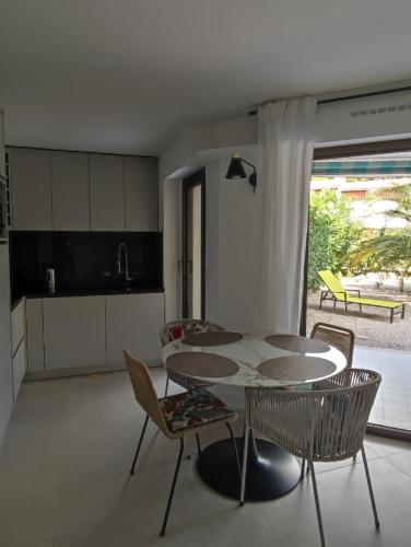 une cuisine et une salle à manger avec une table et des chaises dans l'établissement Le Palmier, jardin privatif, plage 200m, classé 3 étoiles, wifi, garage,rénové en 2024, à Cavalaire-sur-Mer
