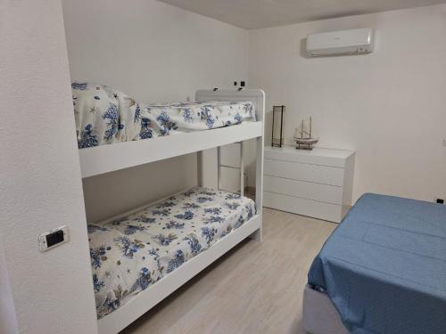 1 dormitorio con 2 literas con flores azules en Casa NOAH, en Teulada