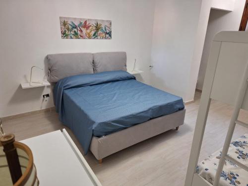 Dormitorio pequeño con cama con manta azul en Casa NOAH, en Teulada
