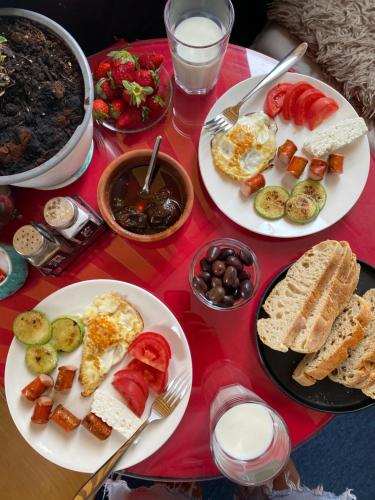 ein Tisch mit Tellern voller Frühstücksspeisen darauf in der Unterkunft Maison D’artiste in Tirana
