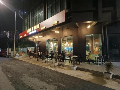 a restaurant with tables and chairs outside at night at T-MOK Hotel in Sepang