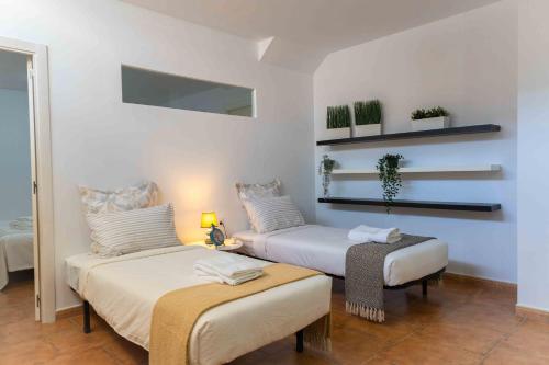two beds in a room with white walls at ¡Las Brisas en Conchas del Rompido! - El Rompido in El Rompido