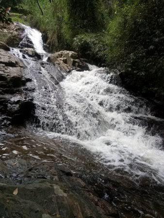 a stream of water rushing down a rocky river at POUSADA SERRANO in São Bento do Sapucaí