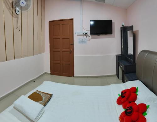 Una habitación con una cama con flores rojas. en Santai Desa Chalet musleem 0nly, en Brinchang