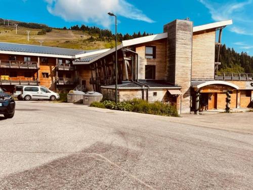 a building with a car parked in front of a street at Nivéole, studio 2 personnes, Les Balcons de Recoin in Chamrousse