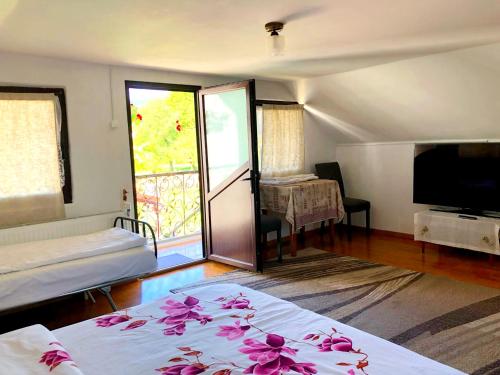 a room with two beds and a television and a table at Casa Paul in Vişeu de Sus