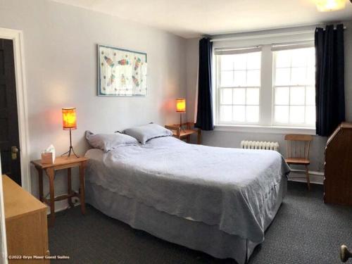 - une chambre avec un grand lit et 2 lampes sur les tables dans l'établissement Bryn Mawr Guest Suites, à Bryn Mawr