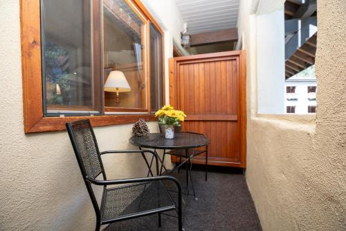 a small table with two chairs and a table with flowers on it at Olympic Village Inn Olympic Valley in Olympic Valley