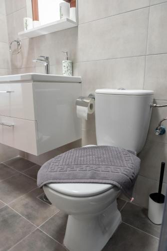 a bathroom with a white toilet and a sink at La Mer Apartments in Skopje