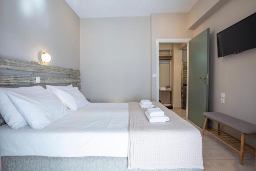 a bedroom with a large white bed with towels on it at Athina résidence in Nydri