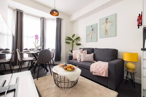 a living room with a couch and a table at Wild Roses Serviced Apartments - Chelsea in London