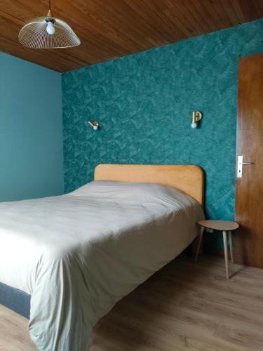 une chambre avec un lit avec un mur bleu dans l'établissement Villa Monette -Le Crotoy, au Crotoy