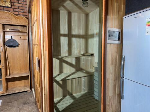 a glass door to a kitchen with a refrigerator at Qafqaz Suite Paradise Chalet & SPA in Gabala