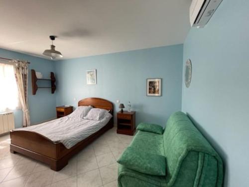 une chambre avec un lit et un canapé dans l'établissement maison 8 pers 300m de la plage, à Dolus-d'Oléron