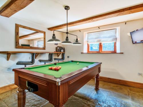 a room with a pool table and two chairs at The Linhay in Watchet