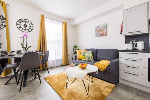 a kitchen and living room with a couch and a table at Wild Roses Serviced Apartments - Chelsea in London