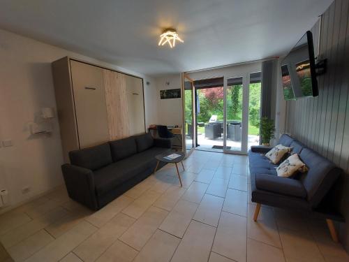 un salon avec un canapé et une table dans l'établissement Rare, cosy studio terrasse au coeur de St-Jorioz, à Saint-Jorioz