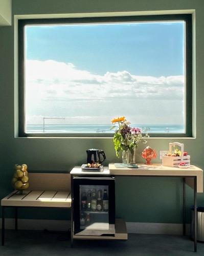 a window in a room with a table and a drink cooler at Maiorano Boutique Hotel in Manfredonia